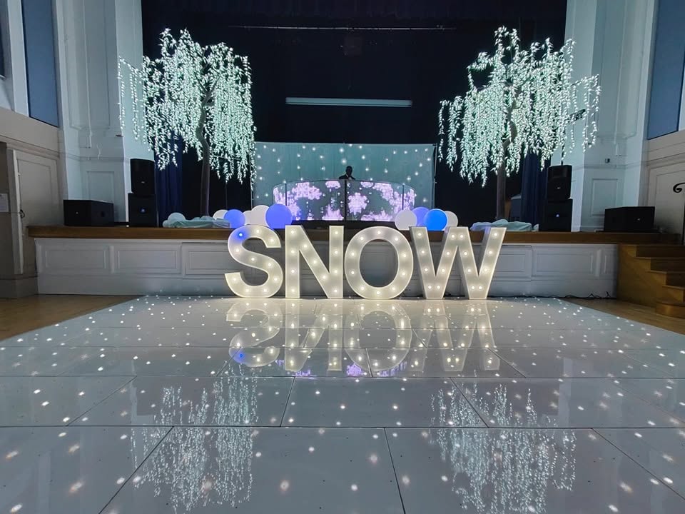Shiny white starlit dance floor refurbishment with LED letters reflecting on the floor